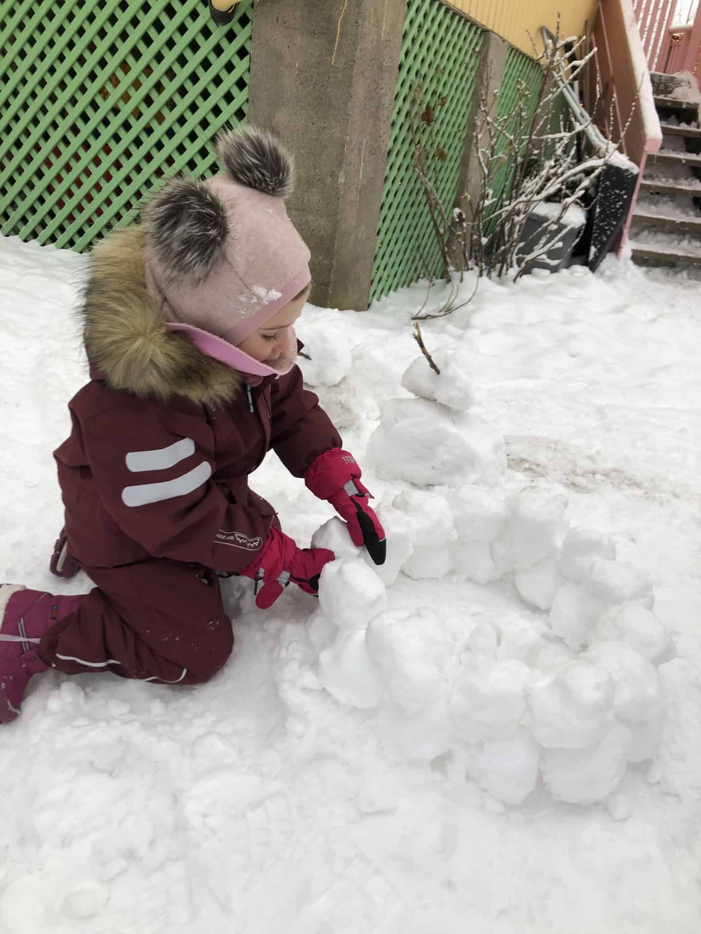 Jente leker i snø